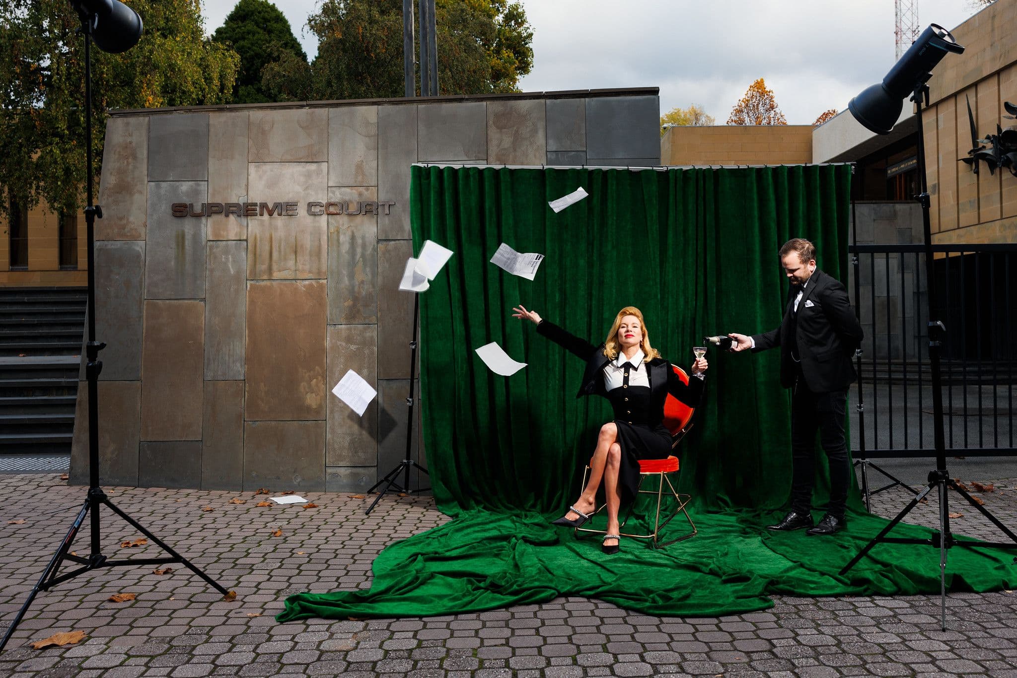 Kirsha in front of the Tasmania supreme court threw documents in the air whilst being poured champagne by a male servant